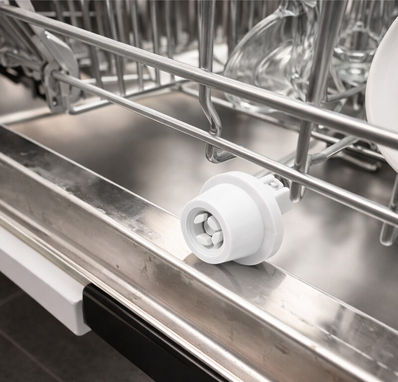 White dishwasher wheel installed on stainless steel lower rack rail inside Bosch dishwasher showing proper mounting position