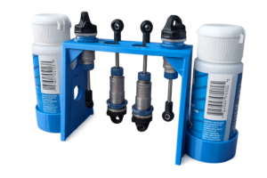 Blue RC shock rebuild stand holding four 1/10 scale RC shocks with dual silicone shock oil bottle holders for maintenance and oil filling.